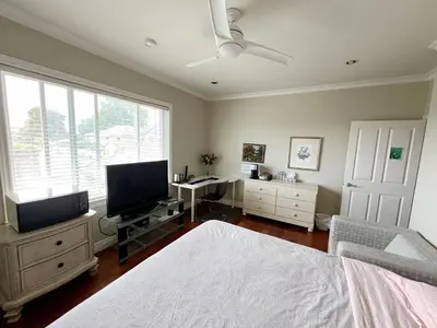 a bedroom with a bed and a desk and a tv at A cozy independent entrance bedroom with a private washroom close to YVR Richmond in Richmond