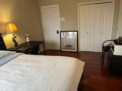 a bedroom with a bed and a desk with a lamp at A cozy independent entrance bedroom with a private washroom close to YVR Richmond in Richmond