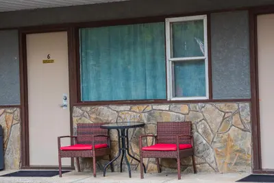 two chairs and a table in front of a building at Lakeview Motel in Christina Lake