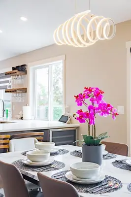 a dining room table with white plates and purple flowers at Cozy 5BD House in North Mission Crawford in Kelowna