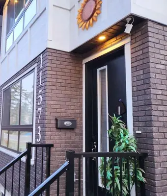 a front door of a brick building with a clock on it at Welcome to Happy Place where Cozy Comfort Meets Exquisite Luxury in Edmonton