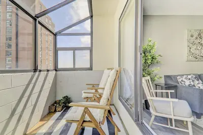 a balcony with two chairs and a window at Roomy Top Floor at Stampede w Free Parking and AC in Calgary