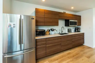 a kitchen with wooden cabinets and a stainless steel refrigerator at NN War Eagles Nest Ravens Ridge 1bed 1 bath in Whitehorse