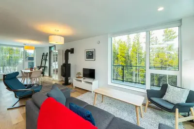 a living room with a couch and chairs and windows at NN War Eagles Nest Ravens Ridge 1bed 1 bath in Whitehorse