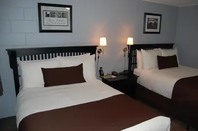 a hotel room with two beds and two lamps at Rest Inn in Terrace