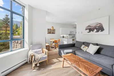 a living room with a couch and a table at Alpenglow Lodge West Coast Wonder by MVA in Whistler