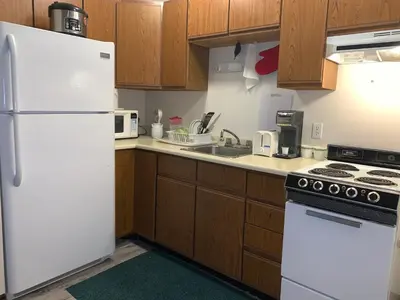 a kitchen with white appliances and wooden cabinets at Destination Family Hotel in Whitehorse