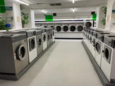 a laundry room with multiple washing machines in it at Destination Family Hotel in Whitehorse