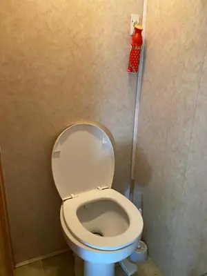 a bathroom with a white toilet in a stall at Comfortable RV in a farm in Nanoose Bay