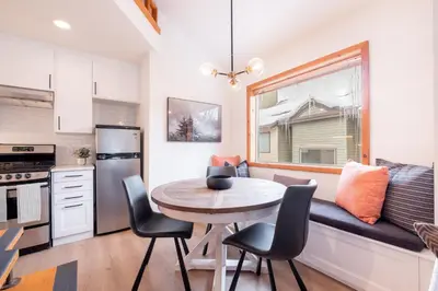 a kitchen with a table and chairs and a window at Powderview by Outpost Whistler in Whistler