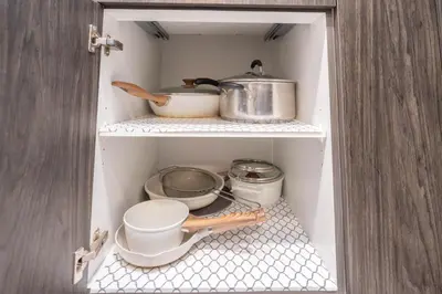a cupboard with some pots and pans in it at Cozy Springs in Calgary