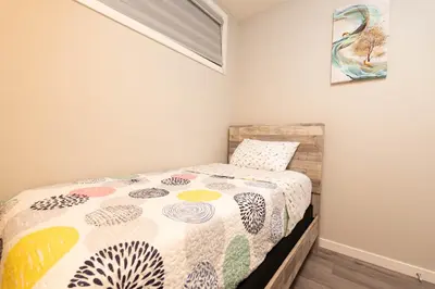 a bedroom with a bed with a colorful comforter at Cozy Springs in Calgary