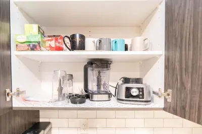 a kitchen shelf with a coffee maker and a blender at Cozy Springs in Calgary