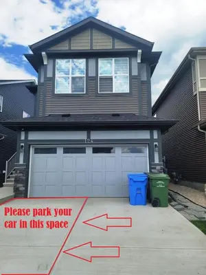 a house with a garage with a sign in front of it at Cozy Springs in Calgary