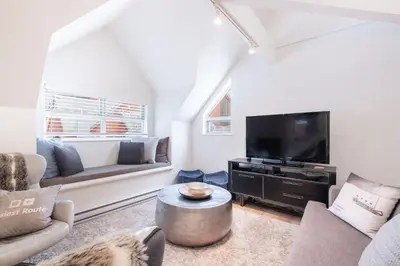a living room with a couch and a tv at Lake Placid Lodge by Outpost Whistler in Whistler