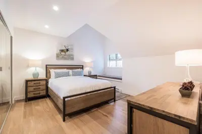 a bedroom with a bed and a desk with a lamp at Lake Placid Lodge by Outpost Whistler in Whistler
