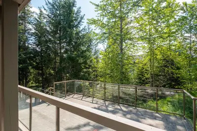 a balcony with a view of the woods at Greyhawk 123 by Outpost Whistler in Whistler