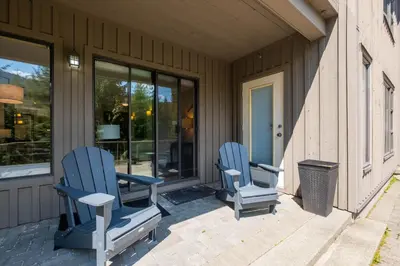 two blue chairs sitting on the front porch of a house at Greyhawk 123 by Outpost Whistler in Whistler
