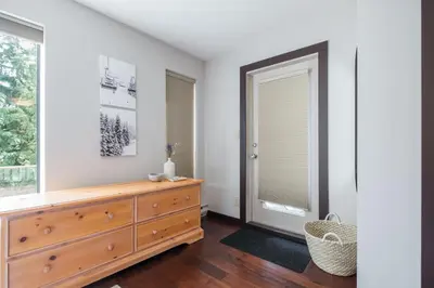 a bedroom with a dresser and a window at Greyhawk 123 by Outpost Whistler in Whistler