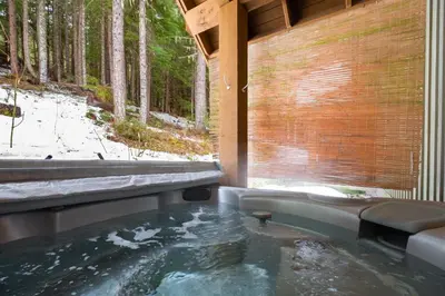 a hot tub in the middle of a room with trees at Mountain Star by Outpost Whistler in Whistler