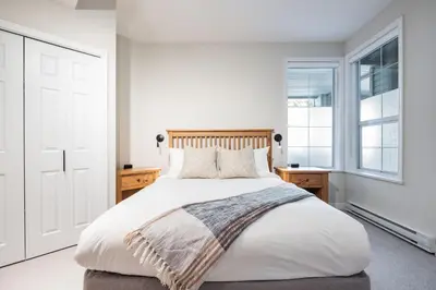 a bedroom with a large white bed and a window at Lynx by Outpost Whistler in Whistler