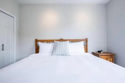a white bed with white sheets and pillows at Lynx by Outpost Whistler in Whistler