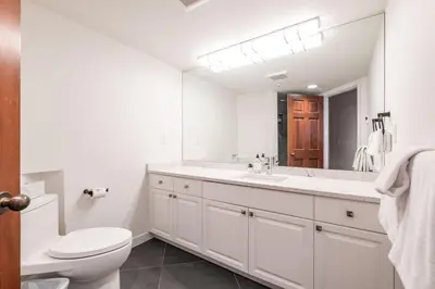 a white bathroom with a toilet and a sink at Lynx by Outpost Whistler in Whistler
