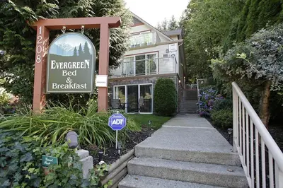 a sign for a bed and breakfast in front of a house at Evergreen Bed & Breakfast in Hope