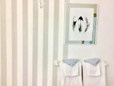 a bathroom with white towels and a picture on the wall at Evergreen Bed & Breakfast in Hope