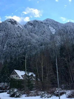 a house in front of a snow covered mountain at Evergreen Bed & Breakfast in Hope