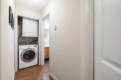 a laundry room with a washing machine and a tv at Glacier's Reach by Outpost Whistler in Whistler