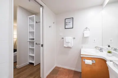 a white bathroom with a sink and a mirror at Glacier's Reach by Outpost Whistler in Whistler