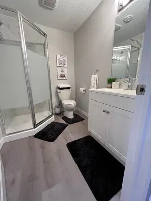 a bathroom with a shower and a toilet and a sink at Private Chic Modern Suite with Kitchen near Spruce Meadows and LRT in Calgary