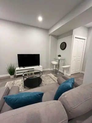 a living room with a couch and a flat screen tv at Private Chic Modern Suite with Kitchen near Spruce Meadows and LRT in Calgary