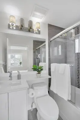 a white bathroom with a toilet and a shower at Family-Friendly, 3 Bed House - Private Backyard-Central Location in Vancouver