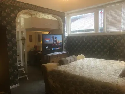a bedroom with a bed and a tv and a mirror at Haterleigh Heritage Inn in Victoria