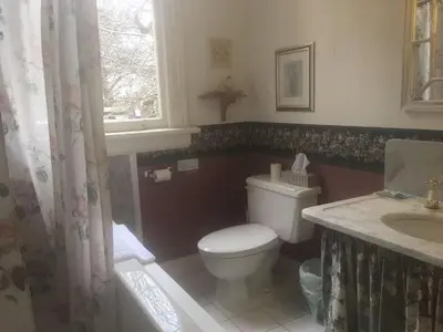a bathroom with a toilet and a sink and a window at Haterleigh Heritage Inn in Victoria