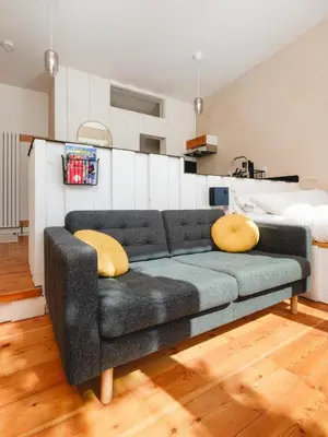 a living room with a couch and a bed at Black Spruce - Orange Door in Whitehorse