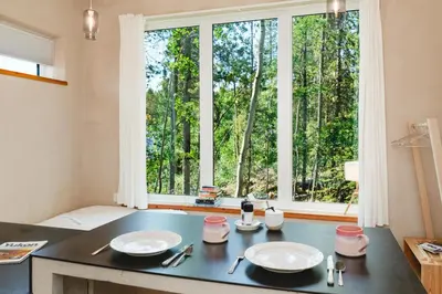 a kitchen with a table with two plates and a window at Black Spruce - Yellow Door in Whitehorse