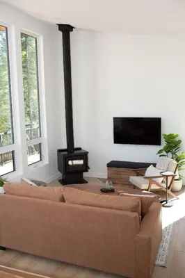 a living room with a brown couch and a fireplace at Luxury Private Cabin In The Rockies in Golden