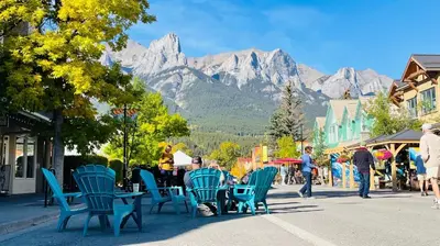 a group of people sitting in chairs on a street at Unit #204 Cozy Mountain View 2BR in Canmore Downtown in Canmore