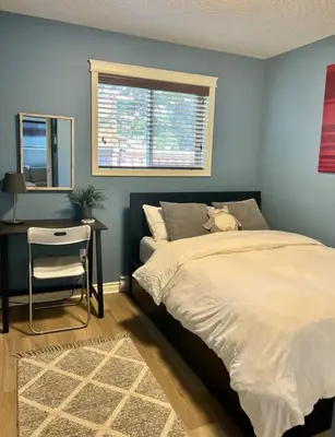 a bedroom with a bed and a desk and a window at Olympic Views - Cozy Modern 2Br Suite in Victoria