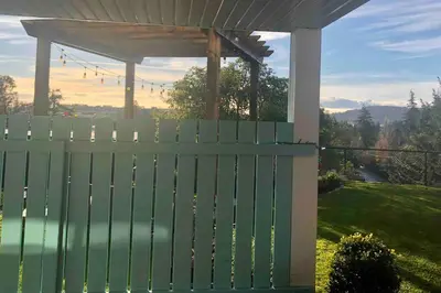 a green fence with a gazebo in a yard at Olympic Views - Cozy Modern 2Br Suite in Victoria