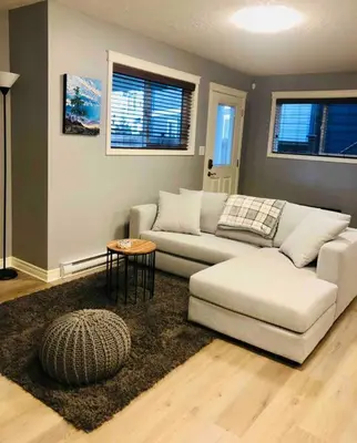 a living room with a couch and a table at Olympic Views - Cozy Modern 2Br Suite in Victoria