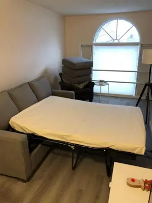 a bed in a room with a couch and a window at unit #303 Mountain view 1BR in Canmore DownTown in Canmore