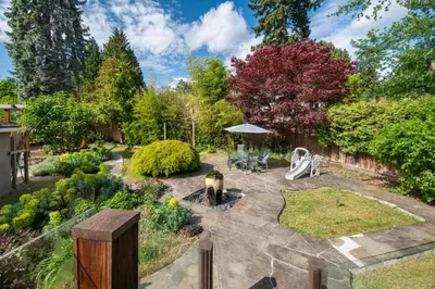 a garden with a stone patio and a fence at Gorgeous 4 Bedroom Garden Level Suite at Vancouver West & UBC in Vancouver