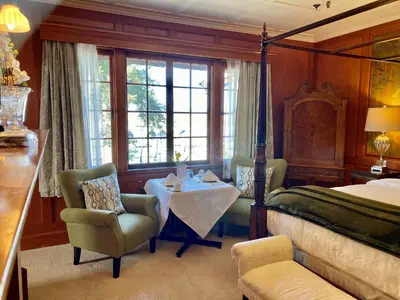 a bedroom with a bed and a table and a chair at The Latch Inn in Sidney