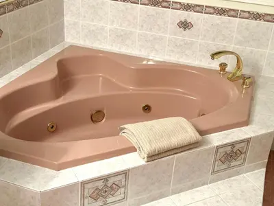 a pink bath tub with a towel in a bathroom at Master Bedroom with Two Queen Sized Bed in Richmond