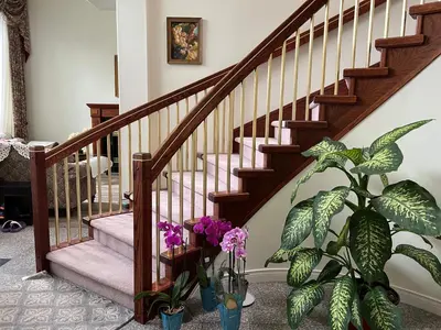 a staircase with a plant and flowers in vases at Master Bedroom with Two Queen Sized Bed in Richmond