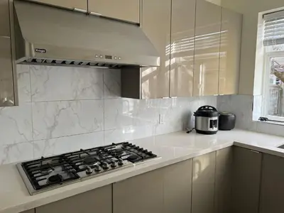 a kitchen with a stove top oven in a kitchen at Master Bedroom with Two Queen Sized Bed in Richmond